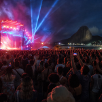 Público reunido diante de um palco iluminado durante festival musical no Rio de Janeiro
