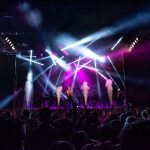 Público acompanha um show ao vivo com iluminação cênica em São Paulo.