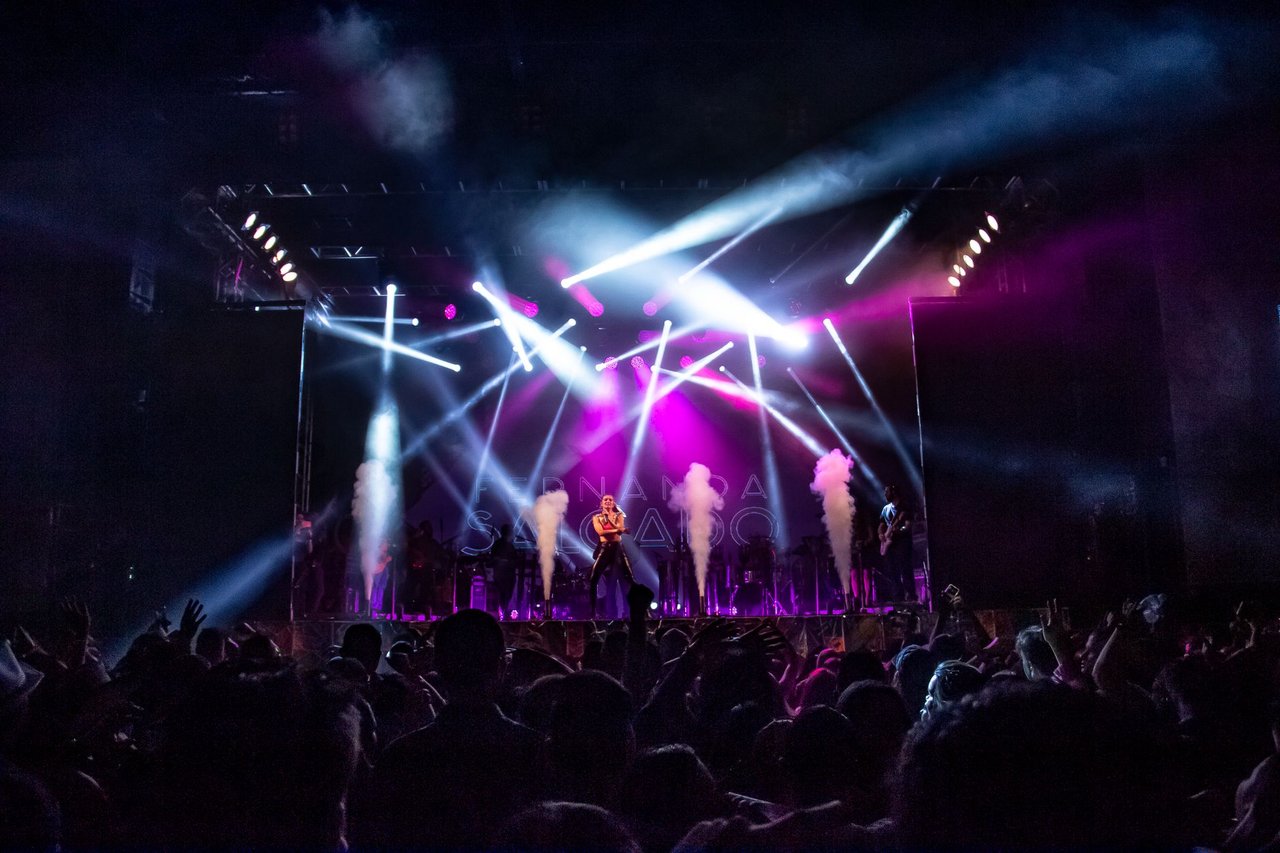 Público acompanha um show ao vivo com iluminação cênica em São Paulo.